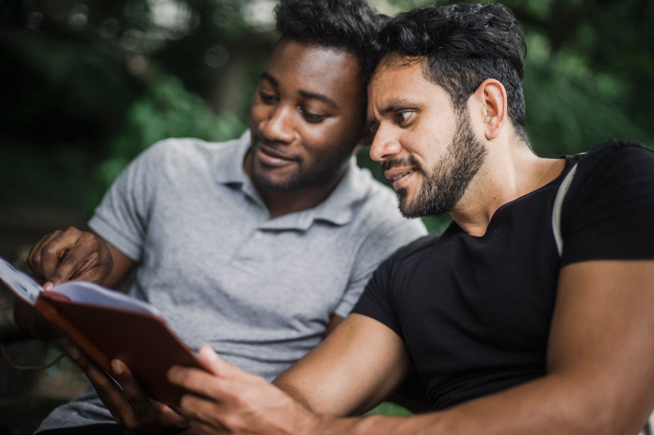 A joyful couple reading together in a serene outdoor setting, embracing intimacy and connection.